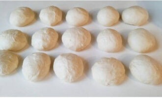 Divide the fluffy dough into segments weighing 50-60 grams and roll into balls, leave for 5 minutes under a towel.