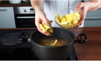 Coloque las verduras y las patatas fritas en el caldo de carne hirviendo. Cocine por 10 minutos.