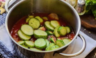 Tilsett så de skivede agurkene i tomatsausen, rør om og la det småkoke i nøyaktig 5 minutter fra starten av kokingen.