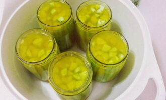 Pour boiling marinade over cucumbers in jars. Place the jars in a large saucepan, cover the bottom with a napkin and cover with boiled lids. Then fill the jars with hot water up to the level of the hangers and sterilize the cucumbers within 5 minutes from the start of boiling water in the pan.