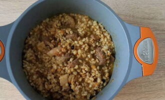 Now add the boiled pearl barley porridge to the beef, stir and cook over low heat for another 10 minutes.