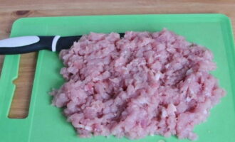 Place the pork tenderloin on a cutting board and use a sharp, heavy knife to cut it into very small, free-form pieces.