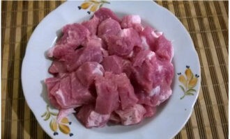 Cut the cooled pork pulp into large cubes so that they can easily pass through the inlet of the meat grinder. Peel the onion head and cut into 4 parts.