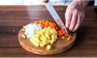 Sbucciare le cipolle, le carote e le patate. Tritare finemente le cipolle e le carote e le patate a cubetti di media grandezza.