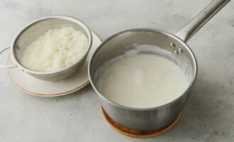 Coloca el arroz en un colador y deja escurrir el agua. Luego coloca el arroz en leche hirviendo y cocina por 20 minutos a fuego lento.Si después de esto el arroz te parece duro, hierve la papilla otros 5 minutos.