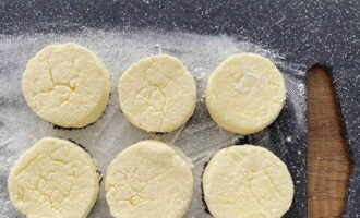 Dust your work surface with flour. Divide the dough into equal parts, roll them into balls, then flatten them on both sides.