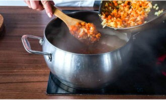 Coloque as batatas picadas em uma panela com o caldo e cozinhe por 20 minutos. Neste momento, frite as cebolas e as cenouras numa frigideira em óleo vegetal, adicione a fritura à sopa 5 minutos antes do final do cozimento.