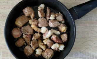 Pour a little vegetable oil onto the heated surface of the frying pan and place the pieces of beef. Fry the meat, stirring occasionally, until golden brown.