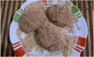 Coloque el pan rallado en un plato. Use sus manos o una cucharada para recoger la carne de cerdo picada, forme chuletas redondas y enróllelas en pan rallado.