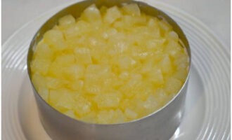 Legg hakket hermetisk ananas på eggelaget og dekk det med majones.