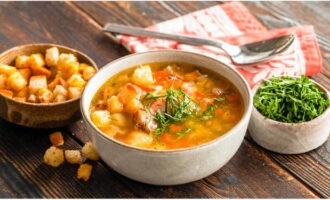 Die Erbsensuppe zum Kochen bringen, den Topf vom Herd nehmen und eine halbe Stunde ziehen lassen. Sie können die Suppe mit Croutons und Sauerrahm servieren. Guten Appetit!