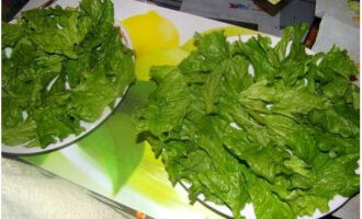 U kunt doorgaan met het samenstellen van de Caesarsalade. Leg de slablaadjes op een plat bord.