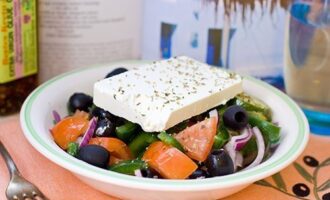 Placez la salade grecque classique préparée à la maison dans des bols à salade en portions, placez une tranche de feta dessus, saupoudrez d'origan et servez immédiatement. Bon appétit! 