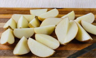 Baked potatoes in the oven are very easy to prepare. Wash the potatoes thoroughly under water using a brush. Blot with napkins and cut into slices of equal thickness.