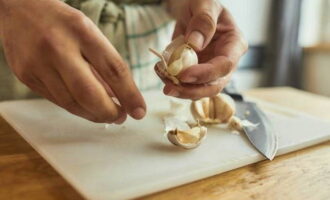 Klassieke Griekse saladedressing is heel eenvoudig te bereiden. Pel het teentje knoflook.