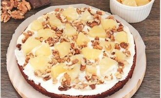 Coloque trozos de piña enlatada y nueces sobre la base preparada. Coloque solo la mitad de las frutas y nueces en la primera capa.