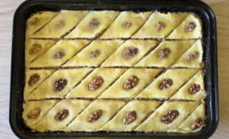 Legen Sie das Backblech in den auf 200 °C vorgeheizten Ofen. Nach einer Viertelstunde die Schnitte vorsichtig entfernen und erneuern, ohne den Boden zu berühren. Nachdem 100 Gramm Butter geschmolzen sind, das Baklava hineingießen und je nach Technik 30–45 Minuten backen.