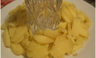 Nehmen Sie eine Schüssel und stellen Sie ein Glas in die Mitte. Wir bilden eine Kartoffelschicht darum.