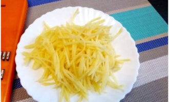 Sbucciare le patate e grattugiarle su una grattugia per carote coreana.