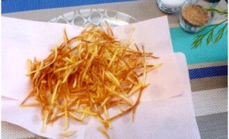 Disporre le strisce di patate su carta assorbente per eliminare il grasso in eccesso.