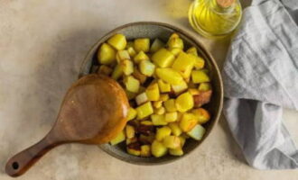 Scaldare una padella con olio vegetale raffinato. Scaricare le patate e friggerle fino a doratura per un quarto d'ora. Rimuovi l'arrosto su un piatto.