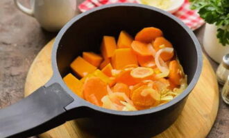 Metti le verdure fritte e i pezzi di zucca in una casseruola o in una casseruola. Riempi il tutto con acqua calda.