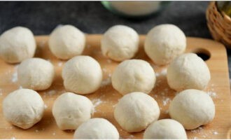 Divide the dough into 10-12 segments, roll into balls and place on a cutting board dusted with flour. Cover with a towel and wait 10 minutes.