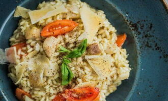 Klassisk italiensk risotto med porcini-sopp er klar. Server med tomater, tynne skiver parmesan og basilikum.