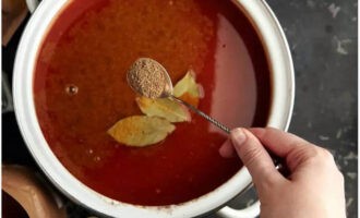 Strain the broth itself and pour it back into the pan. Salt and bring to a boil. Next add the tomato mass and bay leaf. Add utskho-suneli and coriander. Bring to a boil again.