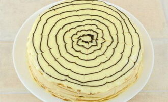 Versare subito il cioccolato fondente fuso sulla torta, disegnando una spirale. Successivamente, usa uno stuzzicadenti per tracciare 8 linee dal centro verso i bordi.