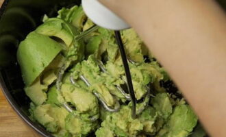 Trasferire la polpa di avocado in una ciotola separata e schiacciarla fino ad ottenere una purea omogenea.