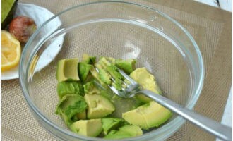 Hæld presset citronsaft over avocadoen og mos ingredienserne til puré.