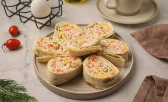 Le rouleau de lavash aux bâtonnets de crabe est prêt ! Le plat est élégant et attrayant. Bon appétit!