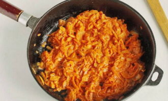 Agregue pasta de tomate y crema agria a las verduras fritas. Mezclar bien los alevines y cocinar un par de minutos más.