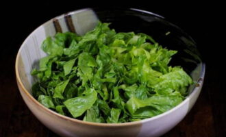 Como preparar uma deliciosa salada de camarão? Lave bem as folhas de alface para retirar a areia com água corrente, seque e coloque em uma tigela.