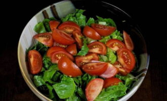 Was de tomaten, verwijder de steeltjes, snijd ze in plakjes en doe ze bij de salade in de kom.