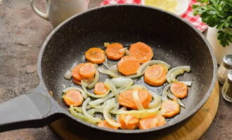 Heat a frying pan with vegetable oil and place onions and carrots on it. Fry for about 3 minutes, stirring occasionally.