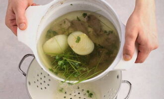 Zeef de afgewerkte bouillon en zet hem terug op de kachel, gooi de groenten weg, koel het vlees af en hak het fijn.