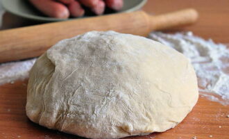 ¿Cómo cocinar salchichas en masa de levadura en el horno? Cogemos la masa terminada, si está congelada hay que descongelarla a temperatura ambiente. 