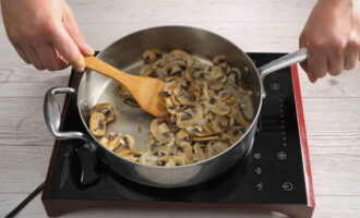 Faites chauffer une poêle avec de l'huile végétale. Nous mettons ici des champignons que nous coupons en fines tranches. Faire frire pendant 10 minutes. Ajoutez ensuite l'oignon. Mélanger les ingrédients et cuire environ 6 minutes.