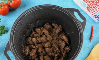 Num caldeirão aqueça o óleo vegetal e refogue a cebola picada por 10 minutos, acrescente a carne e evapore o líquido, doure as rodelas de carne.