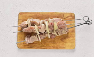 Puneți carnea de porc marinată împreună cu rondele de ceapă pe frigărui și gătiți peste cărbuni. Shish kebab-ul va iesi minunat. Poftă bună!