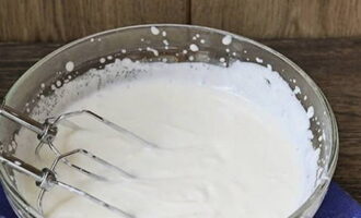 Mentre le torte dorate si raffreddano, prepara la crema: sbatti la panna acida e lo zucchero con un mixer finché i chicchi non si sciolgono.