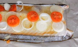 Cortamos también los tomates en rodajas finas y las colocamos sobre el pescado.