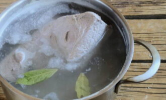 Gleichzeitig das Rindfleisch etwa eine Stunde lang in Salzwasser kochen, während der Hitzebehandlung schwarze Pfefferkörner und Lorbeerblätter in die Brühe geben.