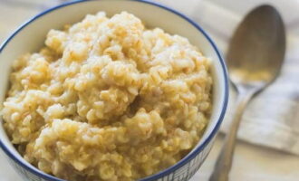 Bubur gandum yang hancur dalam air dalam kuali di atas dapur sudah siap. Hidangkan dan nikmati!