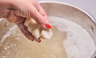 Wenn das Wasser in der Pfanne kocht, eine Prise Salz hinzufügen und die Knödel hinzufügen. Kochen Sie sie zwei Minuten lang in kochendem Wasser, die fertigen Teigtaschen schwimmen dann an der Oberfläche.