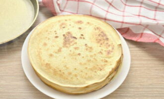 Faites chauffer la poêle, graissez-la avec un peu d'huile végétale et versez-y la pâte par portions.Étalez sur la surface de la poêle et faites frire les crêpes fines jusqu'à ce qu'elles soient dorées des deux côtés.