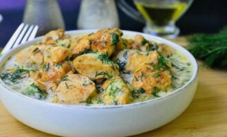 Chicken in cream sauce in a frying pan is ready. Serve to the table!