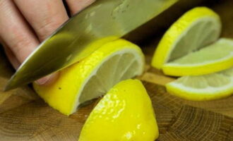 How to cook juicy pink salmon in foil in the oven? Lemons must be thoroughly washed with hot water, or better yet, rinsed with boiling water to remove all chemical treatment from the surface of the peel. Cut one lemon in half lengthwise, then cut each half into not too thin slices. Cut the second lemon in half crosswise.